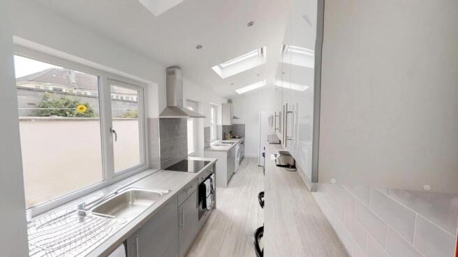 A modern kitchen featuring sleek cabinetry, amp...