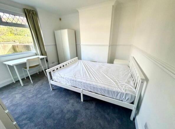A spacious and bright double bedroom featuring ...