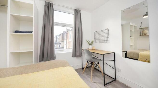A bright and inviting double bedroom featuring ...