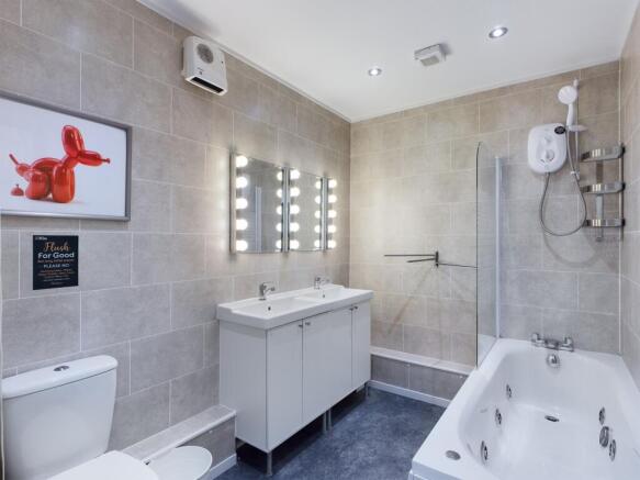A spacious and modern bathroom featuring a rela...