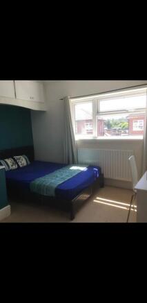 This inviting double bedroom features a comfort...