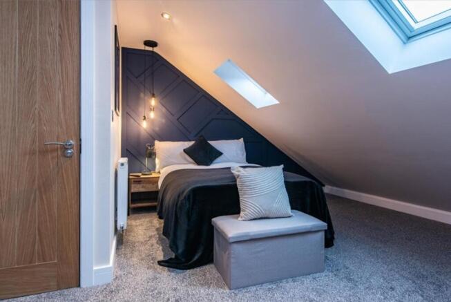 This stylish double bedroom features a cozy amb...