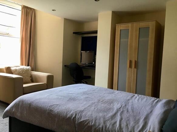 Spacious double bedroom featuring a cozy seatin...