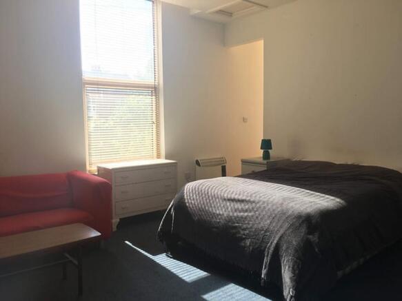 Spacious double bedroom featuring abundant natu...