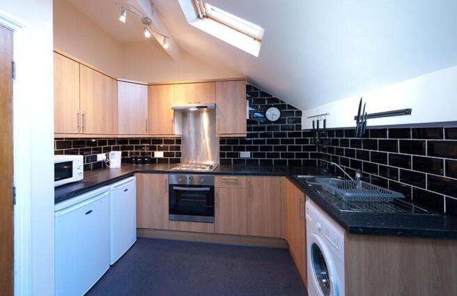 Modern kitchen featuring sleek cabinetry, ample...