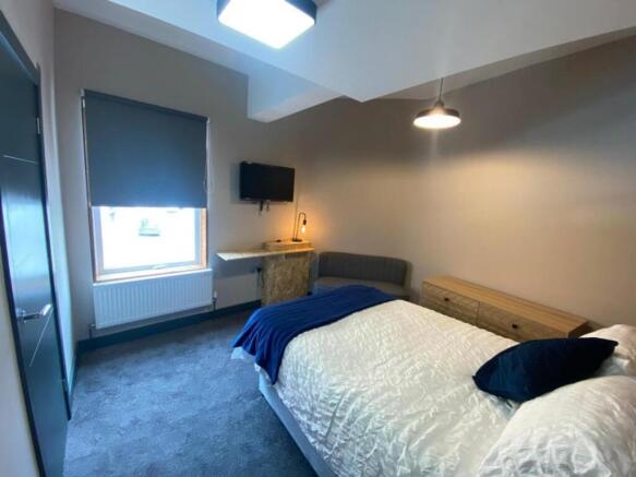 This inviting double bedroom features a cozy la...