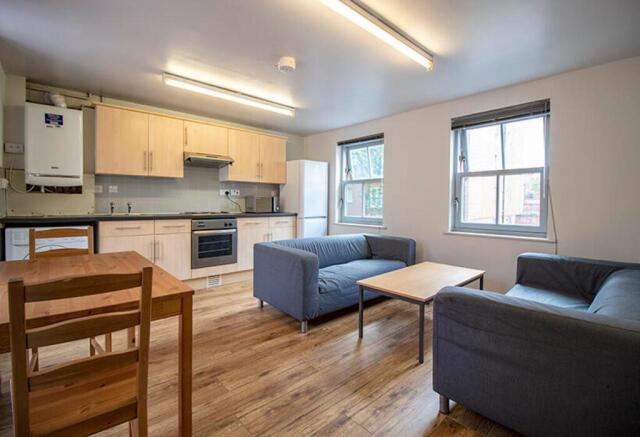 Spacious and modern living room featuring ample...