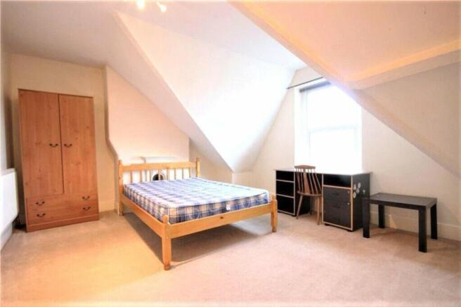 Spacious double bedroom featuring ample natural...