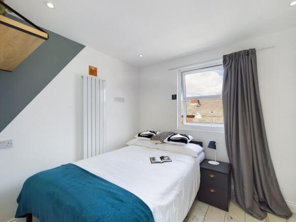 A bright and inviting double bedroom with moder...