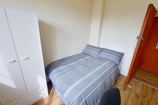 This inviting double bedroom features a comfort...