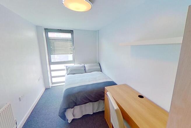 This inviting double bedroom features a comfort...