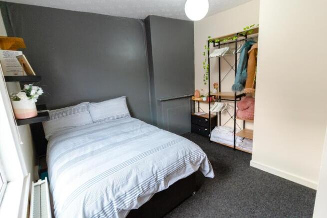 This inviting double bedroom features a cozy at...