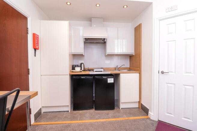 A modern and tidy kitchenette equipped with ess...