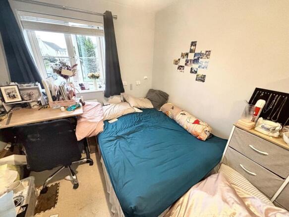 Cozy double bedroom featuring a large bed and a...
