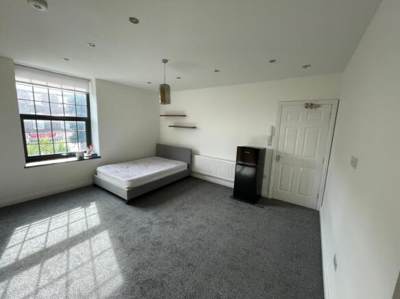 Spacious double bedroom featuring large windows...