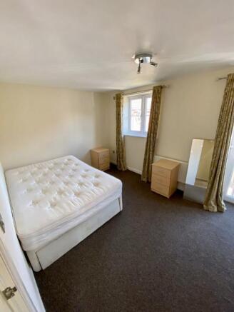 Spacious double bedroom featuring large windows...
