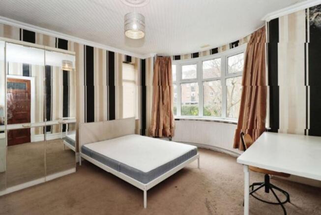 This inviting double bedroom features large win...