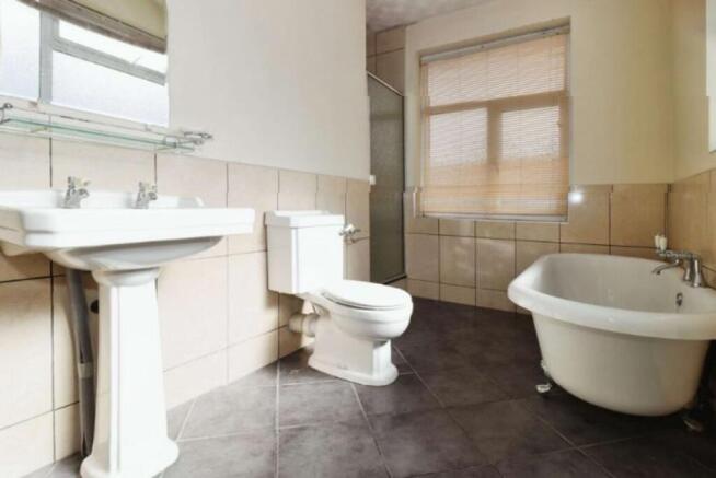 This spacious bathroom suite features a stylish...