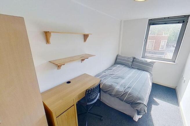 This cozy double bedroom features ample natural...