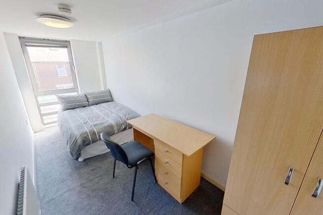 This inviting double bedroom features a comfort...
