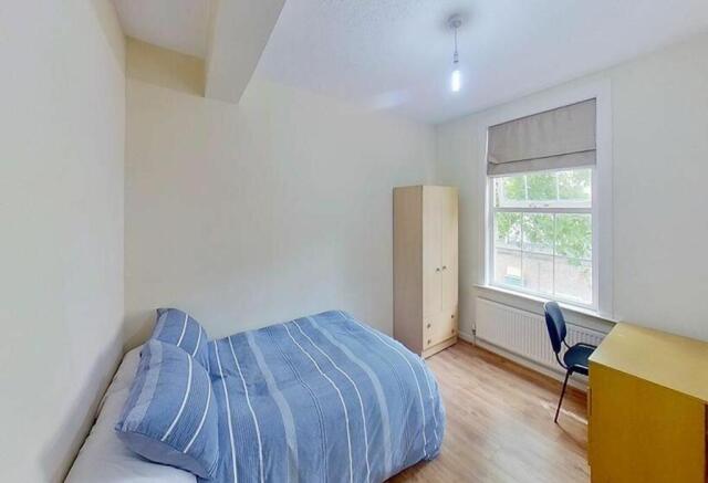 This cozy double bedroom offers a comfortable s...
