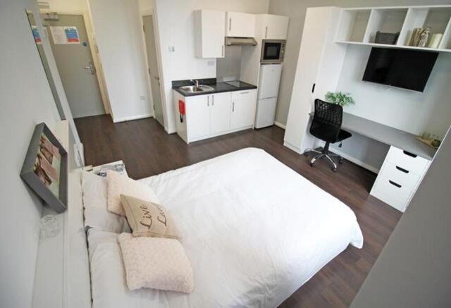 Spacious double bedroom featuring a cozy bed, m...