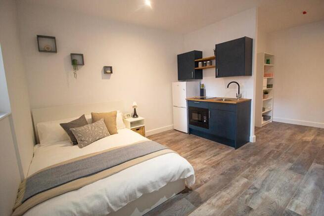 This charming double bedroom features a cozy be...