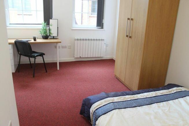This inviting double bedroom features a spaciou...