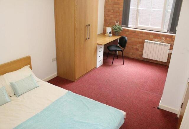 A cozy double bedroom featuring a comfortable b...