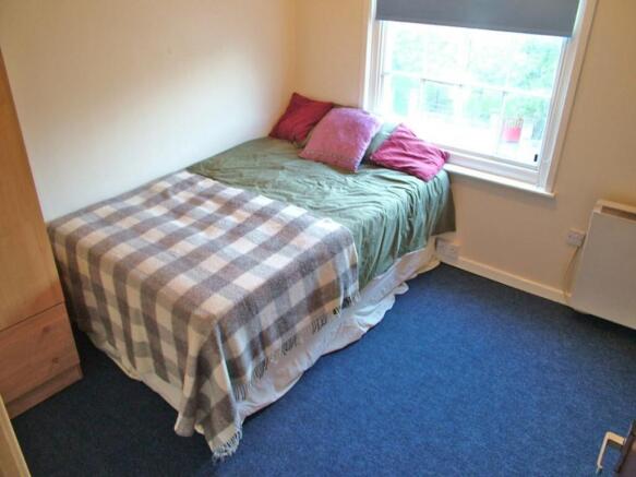 Cozy double bedroom featuring a comfortable bed...