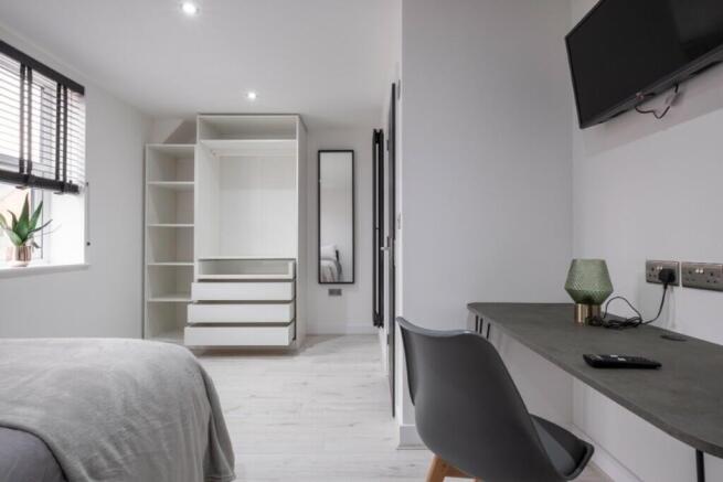 A spacious and bright double bedroom featuring ...