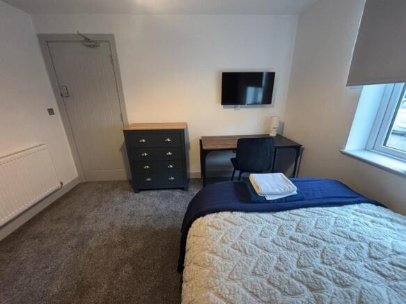A cozy double bedroom featuring a comfortable b...