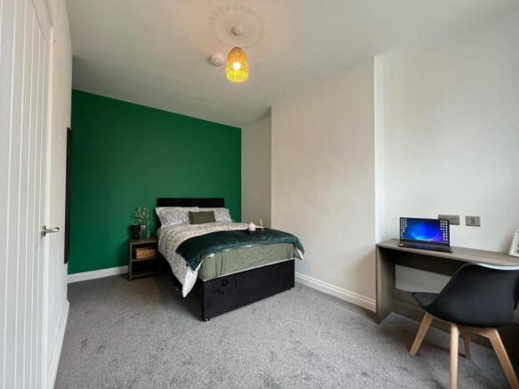 This inviting double bedroom features a stylish...