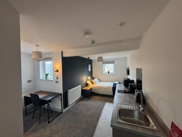 This cozy double bedroom features a well-lit sp...