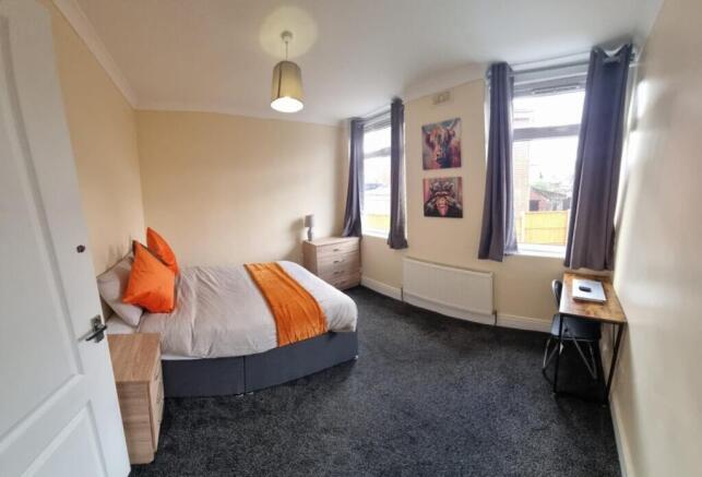 This inviting double bedroom features a comfort...