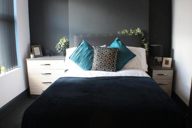 This inviting double bedroom features a comfort...