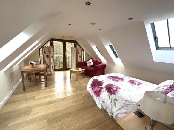 A spacious master bedroom featuring large windo...