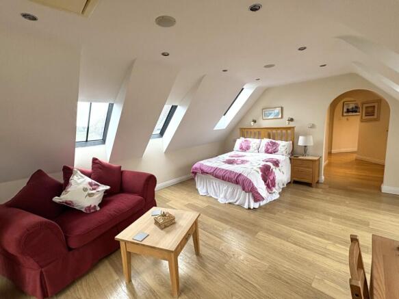 Spacious master bedroom featuring a cozy seatin...