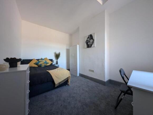 Spacious double bedroom featuring a cozy bed ad...