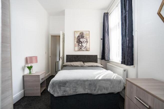 This cozy double bedroom features a stylish des...