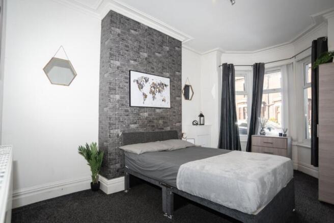 This stylish double bedroom features a comforta...