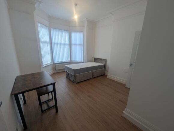 Spacious double bedroom featuring large windows...