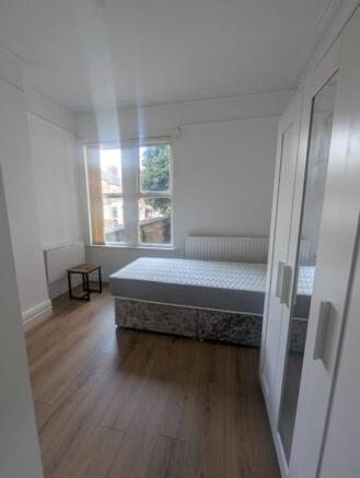 This bright double bedroom features large windo...