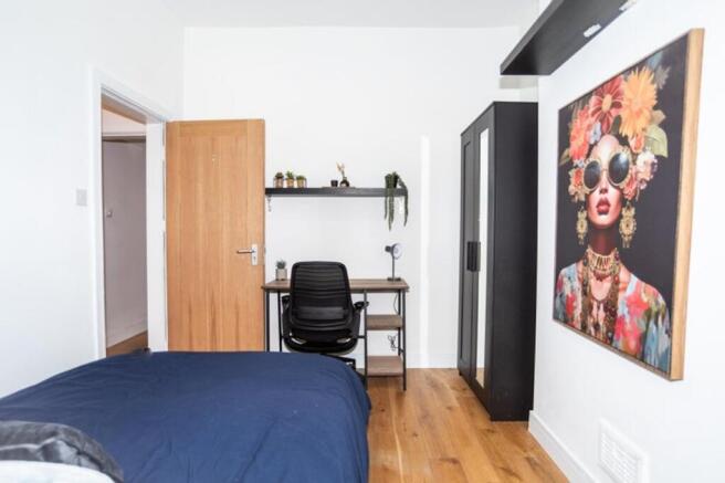 This inviting double bedroom features a cozy be...