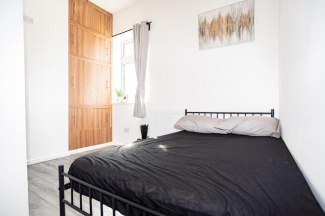 A cozy double bedroom featuring a stylish bed, ...