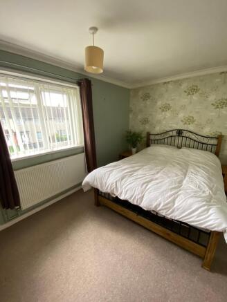 This inviting double bedroom features a comfort...