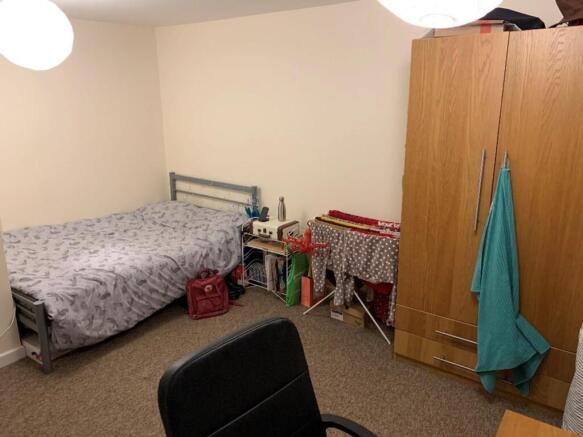 This cozy double bedroom features ample natural...