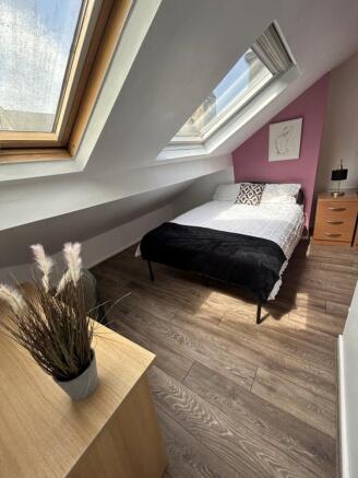 A charming double bedroom featuring ample natur...