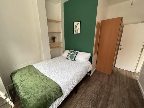 This inviting double bedroom features a comfort...