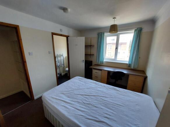 Spacious double bedroom featuring ample natural...